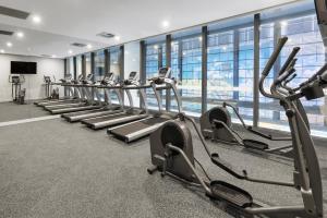 una fila de máquinas de cardio en un gimnasio en Meriton Suites King Street Melbourne en Melbourne