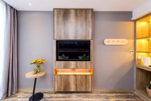 a room with a wall with a tv and a table at Heye International Youth Hostel in Chongqing