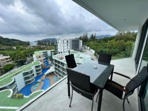 a balcony with a table and chairs and a view at Twin Sands Resort Penthouse in Patong Beach