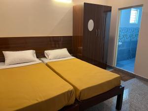 two beds sitting next to each other in a bedroom at Rt Service Apartments Hotel in Velankanni