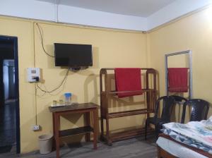 a room with a tv and a table and a chair at Hotel Amala in Tawang