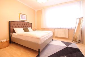 Un dormitorio con una cama y una ventana grande en Retro Apartment, en Sarajevo 2 fotos más