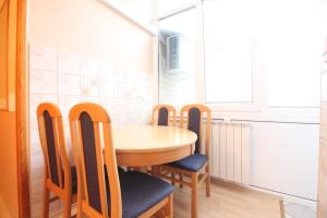 Una mesa y cuatro sillas en una habitación en Retro Apartment, en Sarajevo