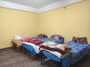 a room with two beds with blankets on them at Hotel Amala in Tawang