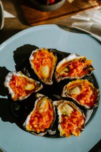 a plate of oysters with sauce and tomatoes on it at Hotel Australasia in Eden