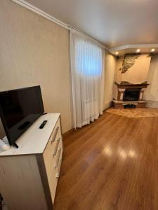 an empty living room with a television on a desk at Grand Apartment in Nelipyno +14 photos