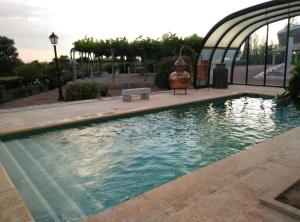 una piscina en un parque con un edificio en finca el descanso manchego, en Tarancón