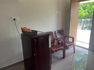 a room with two chairs and a cabinet and a door at RT Service Apartment Villas in Velankanni
