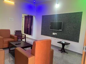 a living room with a couch and a flat screen tv at RT Service Apartment Villas in Velankanni