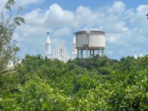 a church and a water tower on top of trees at RT Service Apartment Villas in Velankanni