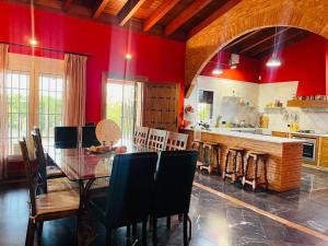a kitchen with red walls and a table and chairs at finca el descanso manchego in Tarancón