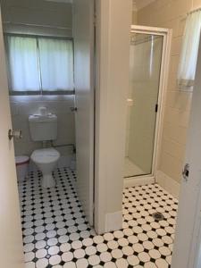 a bathroom with a white toilet and a shower at Warrumbungles Mountain Motel in Coonabarabran