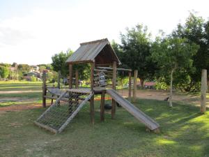 un parque infantil de madera con un tobogán en un parque en Hotel Lindoia Rural, en Lindóia