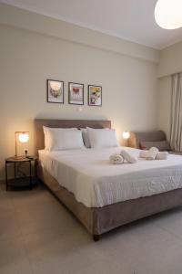 una camera da letto con un grande letto bianco con due lampade di ATHENS STORIES ad Atene
