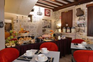 a restaurant with two tables with red chairs and a buffet at Hotel Reine Mathilde in Bayeux