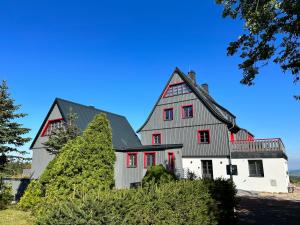 WaldidylleにあるZugspitze Apartment GLÜCK.AUFの赤い窓のある大きな白い家