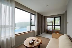 a living room with a couch and a large window at Dengguan Seaview Villa Designer Homestay -Zhoushan Putuo Baisha Island Branch in Zhoushan