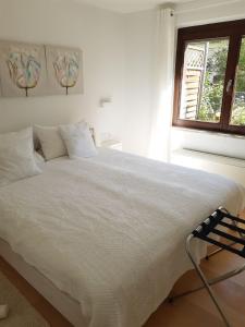 ein weißes Bett in einem Schlafzimmer mit einem Fenster in der Unterkunft Ferienapartment Ida in Lorch