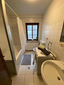 een badkamer met een toilet, een wastafel en een bad bij Weilburg-Domizil in Weilburg