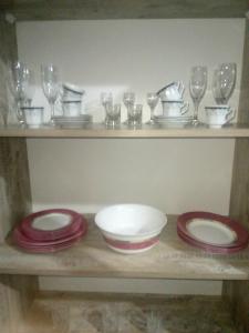 a shelf with plates and wine glasses on it at NIZAMI Street flat in Baku