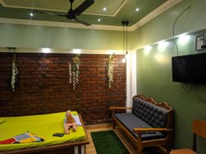 Habitación con cama, sofá y TV. en Budget-Friendly Luxury Air-Conditioned Deluxe Suite at Pravuprasad Homestay, en Bhubaneshwar