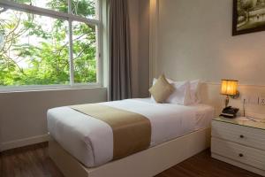a bedroom with a large bed with a window at Anik Boutique Hotel in Phnom Penh +48 photos
