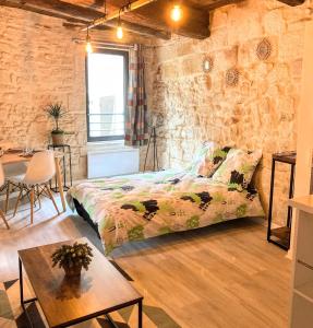 Schlafzimmer mit einem Bett und einem Tisch in der Unterkunft Immeuble 3 Apparts Centre historique St Gilles MaisoncarreeConciergerie in Saint-Gilles