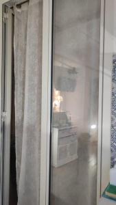 a sliding glass door with a curtain in a room at Brezza Marina in Isola delle Femmine