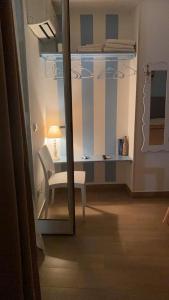 a mirror in a room with a chair and a lamp at Brezza Marina in Isola delle Femmine