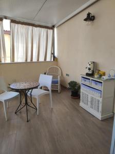 a living room with a table and chairs and a kitchen at Brezza Marina in Isola delle Femmine