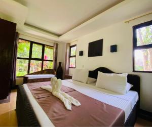een slaapkamer met een bed met een handdoek erop bij CATANAUAN COVE White Sand Beach Resort in Catanauan