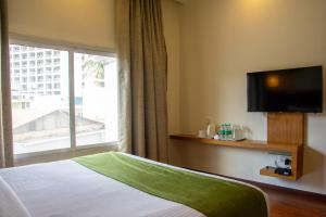 a hotel room with a bed and a window at Hotel Ramanashree Richmond in Bangalore