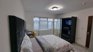 a bedroom with a bed and a television in it at Stylish Suites with kitchenette in London Colney