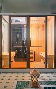 een kamer met een sauna met glazen deuren bij Pavillon Boutique Hotel & Apartment Nha Trang in Nha Trang