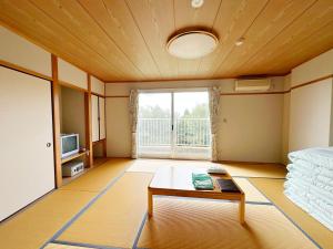 a room with a bed and a table and a tv at 森林公園スイス村 風のがっこう京都 in Kyotango