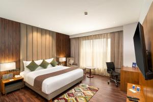 a hotel room with a bed and a television at Cygnett Inn Imperial Tezpur in Tezpur