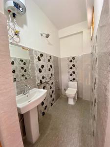 La salle de bains est pourvue d'un lavabo et de toilettes. dans l'établissement Hotel Mansarovar Inn, à Munsyari