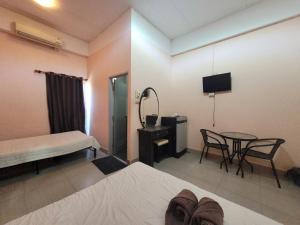 1 dormitorio con cama, mesa y TV en โรงแรมบ้านเปรมศิริ, en Amnat Charoen