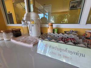 un comptoir avec un mélangeur et une boîte sur celui-ci dans l'établissement โรงแรมบ้านเปรมศิริ, à Amnat Charoen