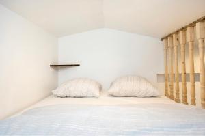 sypialnia z łóżkiem i dwiema poduszkami w obiekcie Villa des palmiers, Studio cosy w mieście Villeneuve-sur-Lot