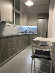 a kitchen with a white table and a white table and a counter at Elia's boutique apartment in Sparta +7 photos