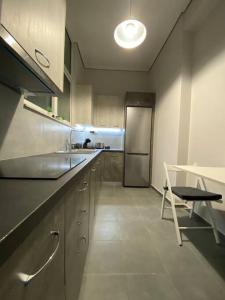 a kitchen with a sink and a table and a refrigerator at Elia's boutique apartment in Sparti