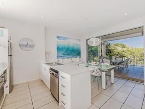 cocina con mesa y vistas al océano en Metzo Noosa Resort, en Noosaville