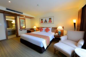 a hotel room with a bed and a chair at Silom Serene A Boutique Hotel - SHA Extra Plus in Bangkok