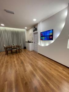 a living room with a table and a tv on a wall at Nizwa Park House Apartment in Nizwa