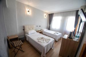 a hotel room with two beds and a table at Mekan Villa Otel in Selçuk