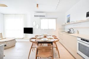 eine Küche und ein Esszimmer mit einem Tisch und Stühlen in der Unterkunft The Levana 3BR Duplex Penthouse by HolyGuest in Tel Aviv