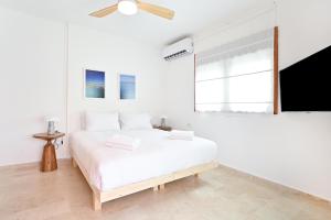ein weißes Schlafzimmer mit einem weißen Bett und einem Fenster in der Unterkunft The Levana 3BR Duplex Penthouse by HolyGuest in Tel Aviv