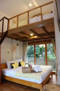 a bedroom with a bunk bed in a room at บ้านพราวพร้าว Baan Proud Proud in Khanom