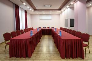 einen langen Tisch in einem Zimmer mit roten Vorhängen und Stühlen in der Unterkunft Alpina Resort by Stellar Hotels, Tsaghkadzor in Zaghkadsor